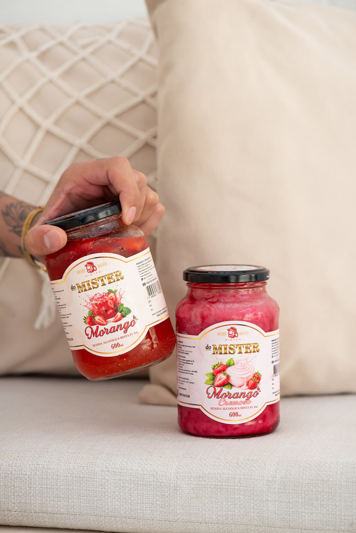 Potes de morango e morango cremoso num sofá claro
